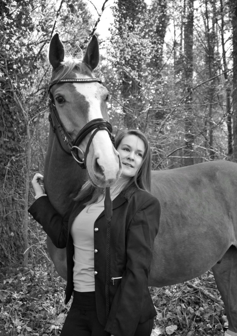 Inhaberin mit ihrem zweiten Pferd.
Das Pferd schaut ihr über die Schulter, beide blicken in die gleiche Richtung